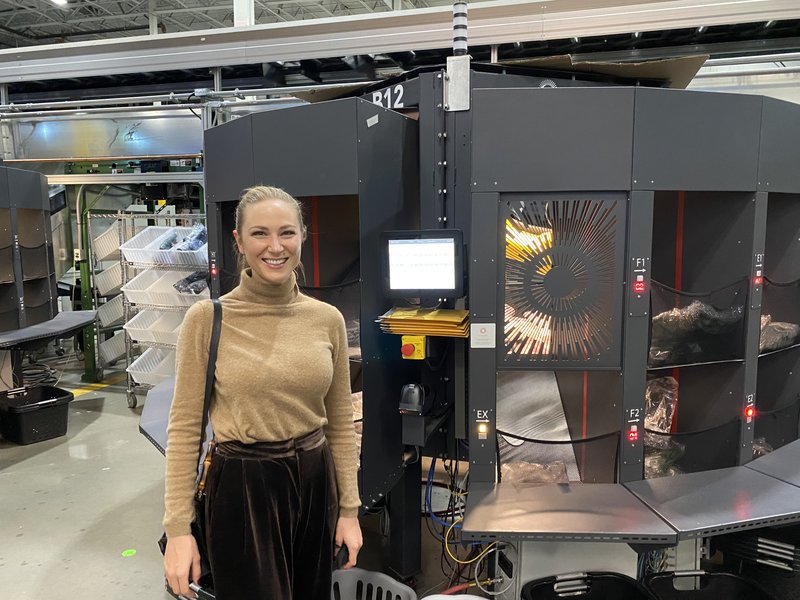 Yasya at Kindred AI on the warehouse floor with the robotic sorting system